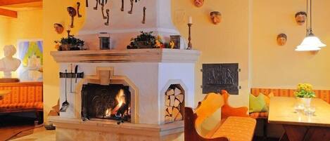 A cozy room with a fireplace, wooden furniture, and decorative wall art.