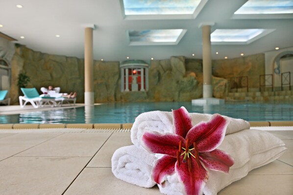 A pool area with a view of the interior, including a stone wall and a pool. - Dorint Sporthotel Garmisch-Partenkirchen (Garmisch-Partenkirchen)