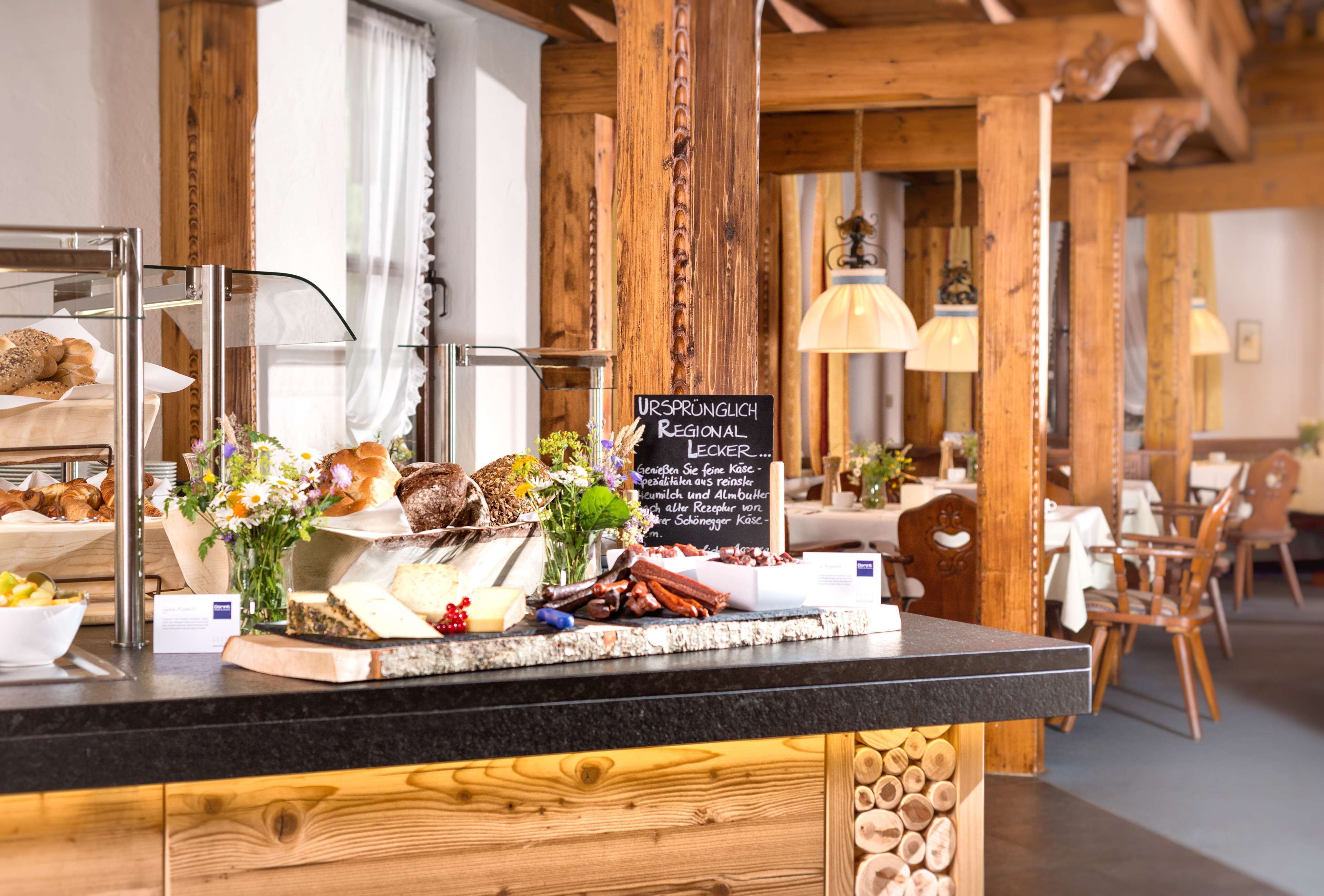 A breakfast buffet with various breads, pastries, and cheeses.