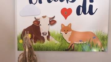 Un coche de juguete y un mural con animales y texto en una habitación.