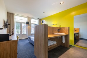 Relax in a spacious room with a large bed, desk, and seating area, offering a view of the outdoors.