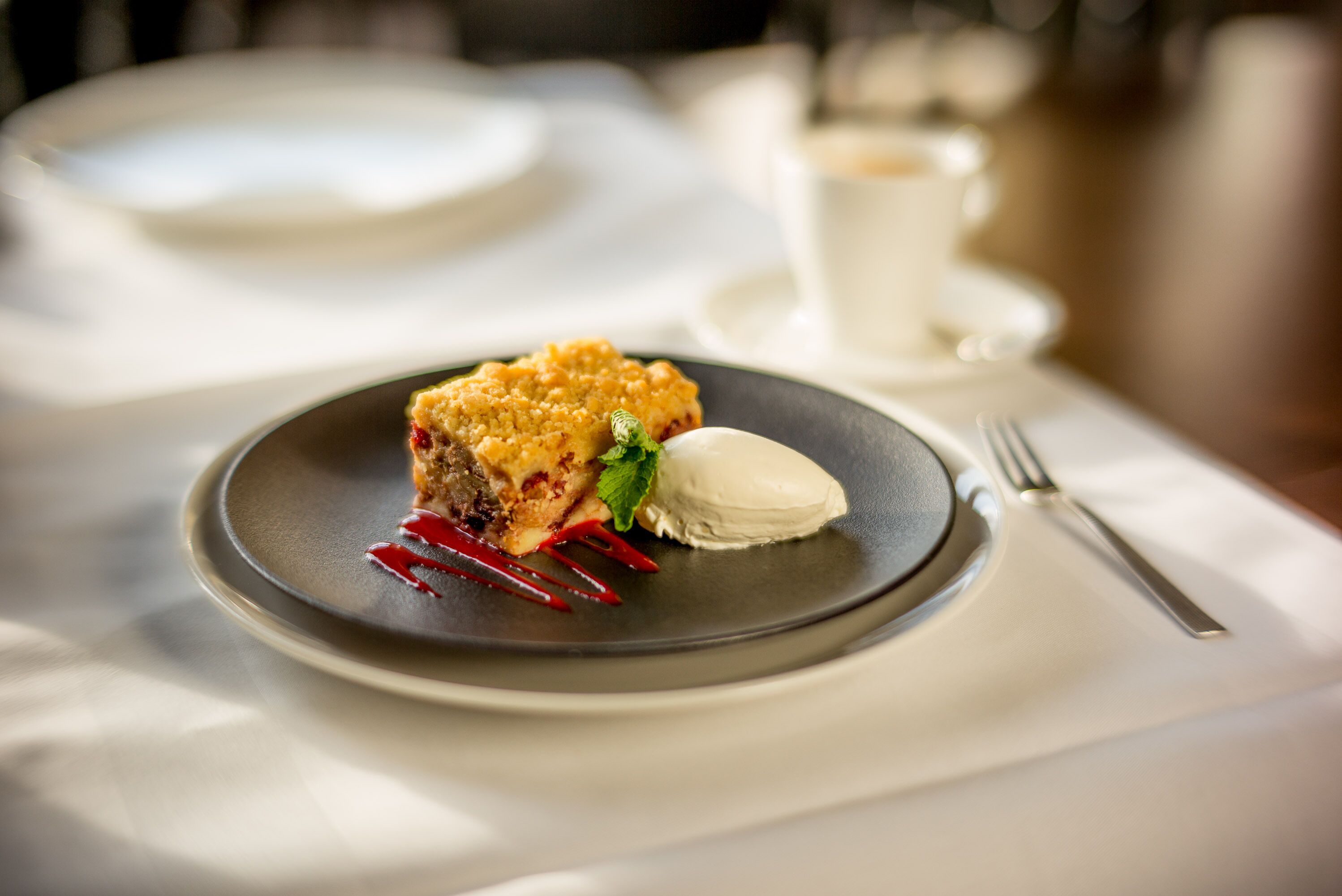 A dessert plate with a slice of cake and a scoop of ice cream on a table.