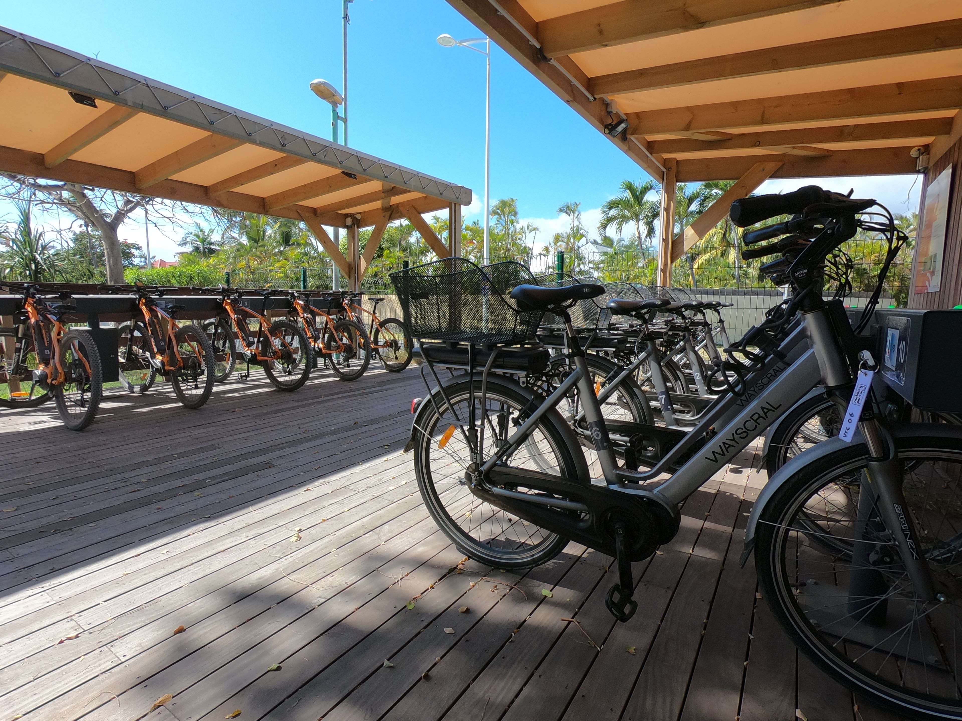 Et cykelforgårdsudlejningssted med flere cykler og et siddeområde.