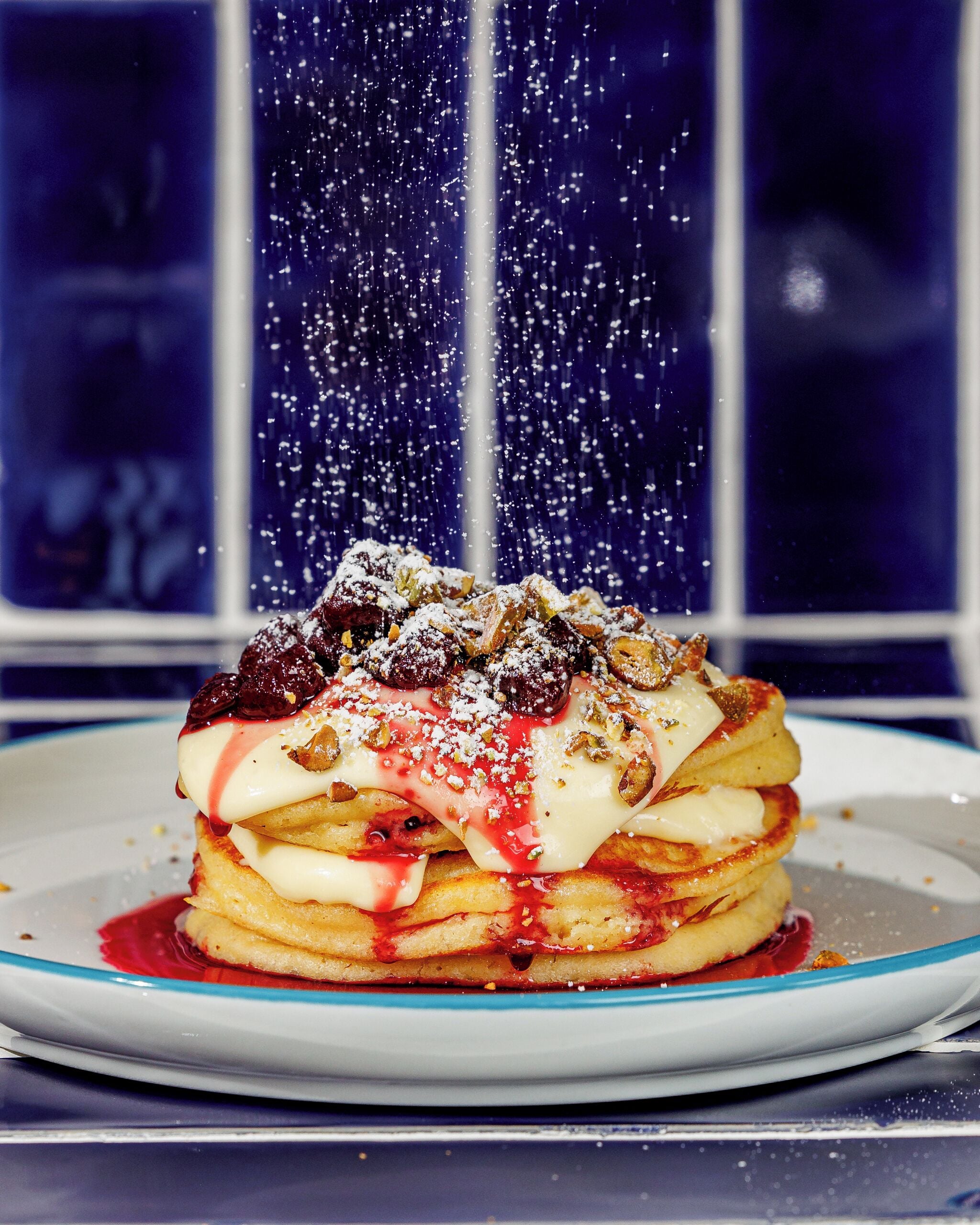 A stack of pancakes with toppings, served on a plate.