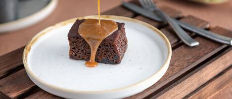 A dessert on a plate with a sauce being poured over it.
