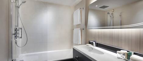 A modern bathroom with a glass-enclosed shower, a large mirror, and a vanity with a sink and towel rack.