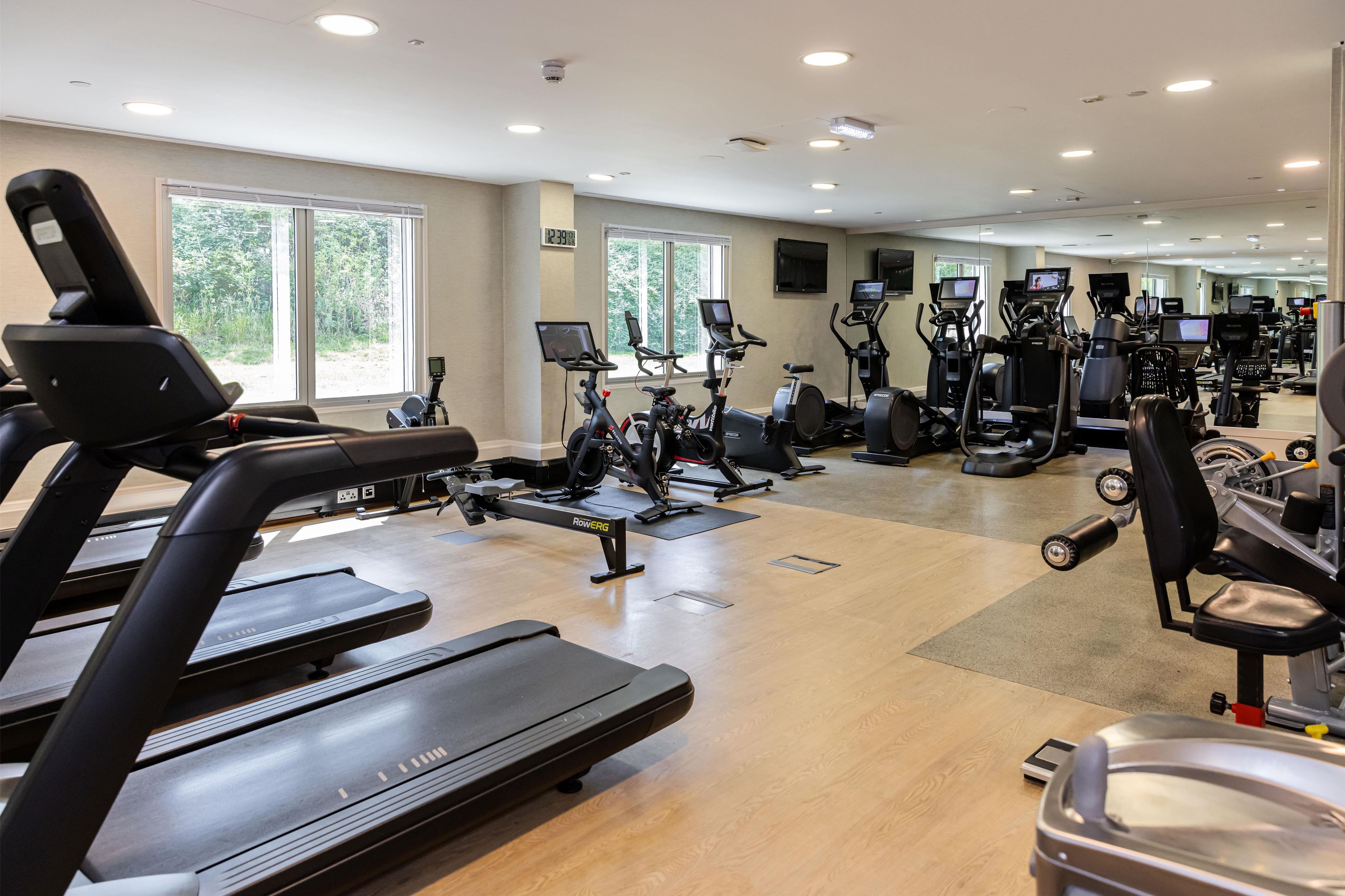 A gym with treadmills, elliptical machines, and weight equipment.