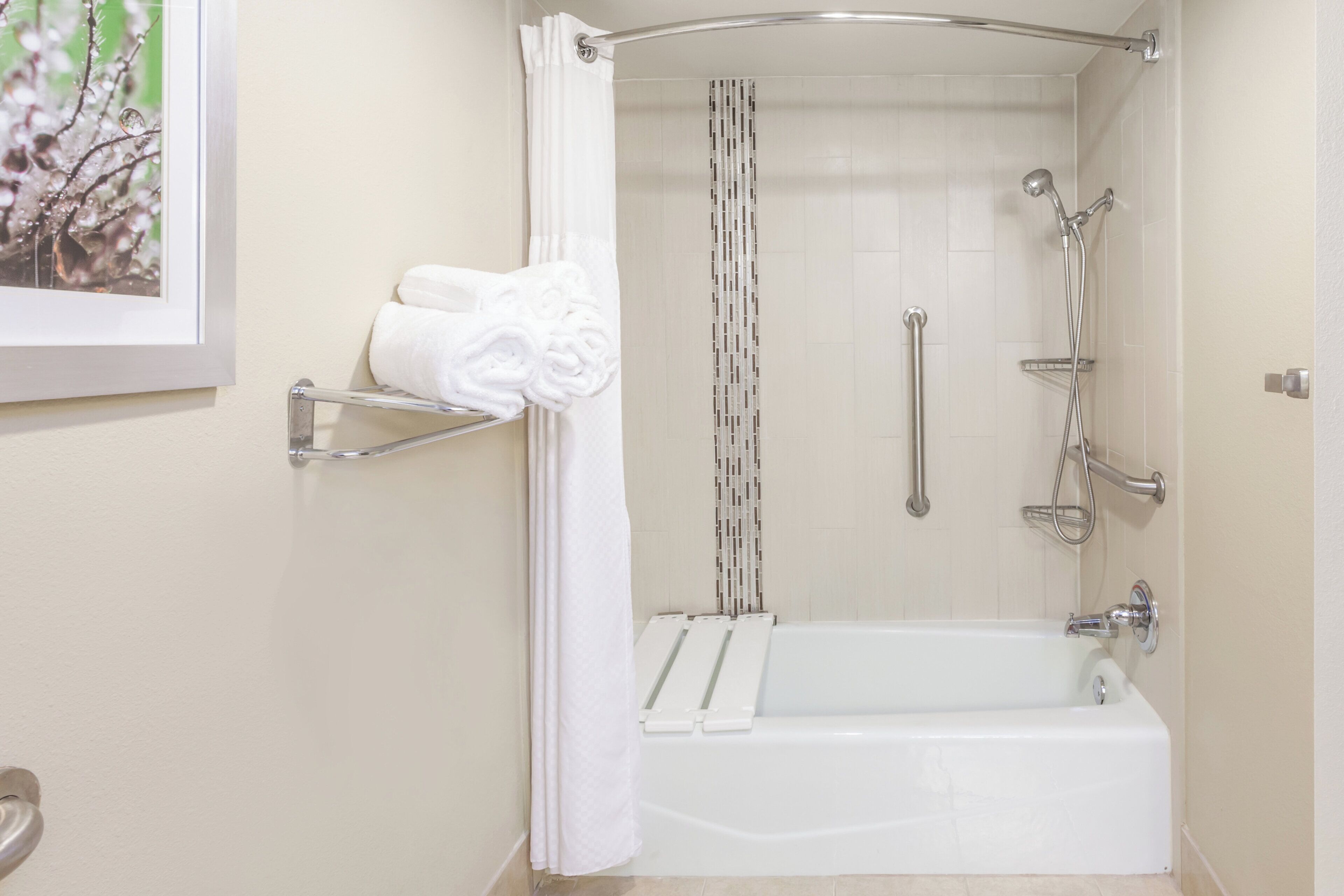 Un baño con bañera, ducha y barra para toallas.