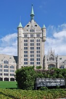 Edificio de la Administración del Sistema de la Universidad Estatal de Nueva York, con una destacada torre del reloj y elementos arquitectónicos góticos.