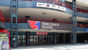 Un immeuble à plusieurs étages, sur lequel on peut voir l’enseigne du Times Union Center, ainsi qu’un guichet mobile pour l’achat de billets et une billetterie.