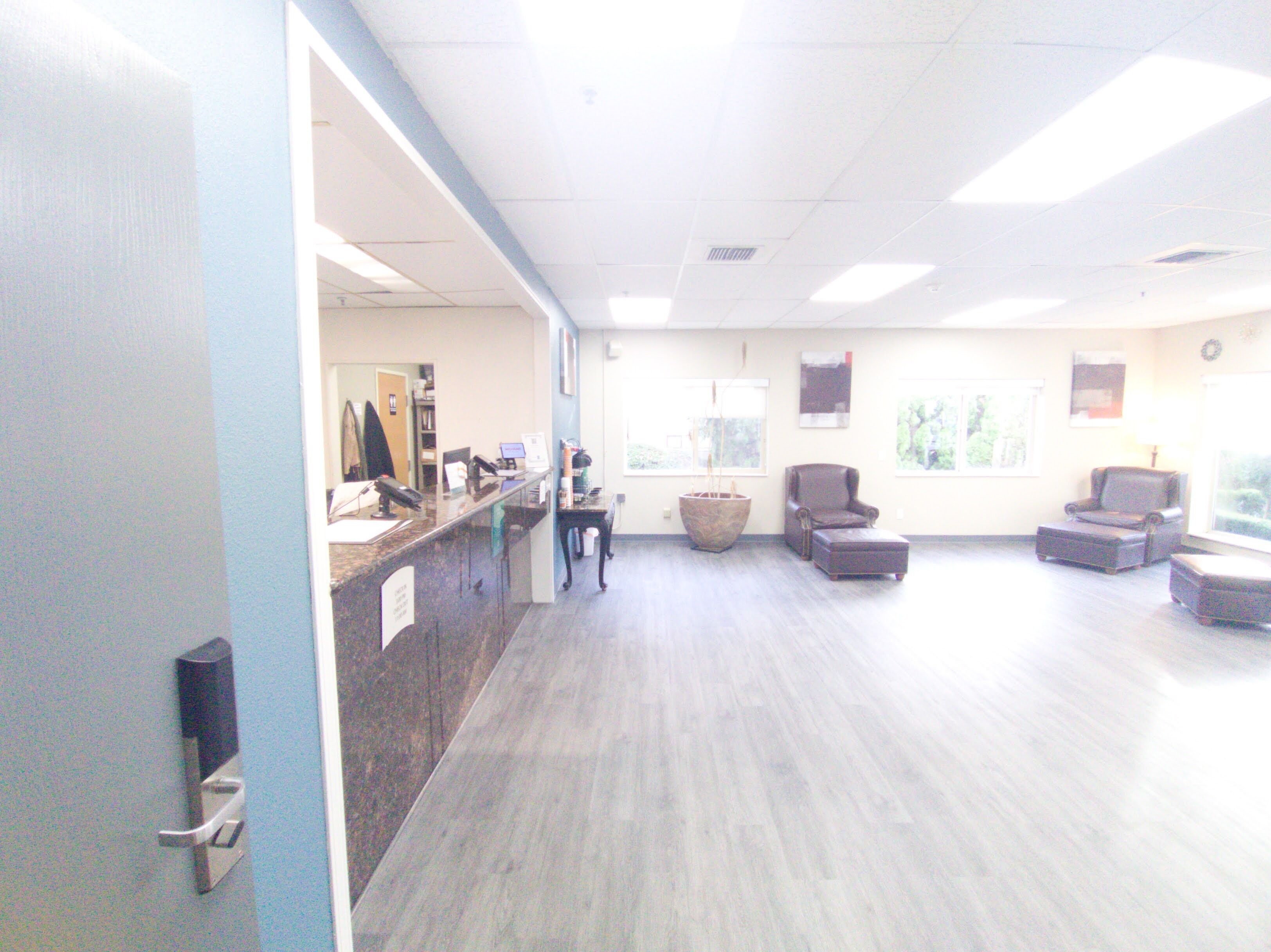 A reception area with a counter, chairs, and a large window.