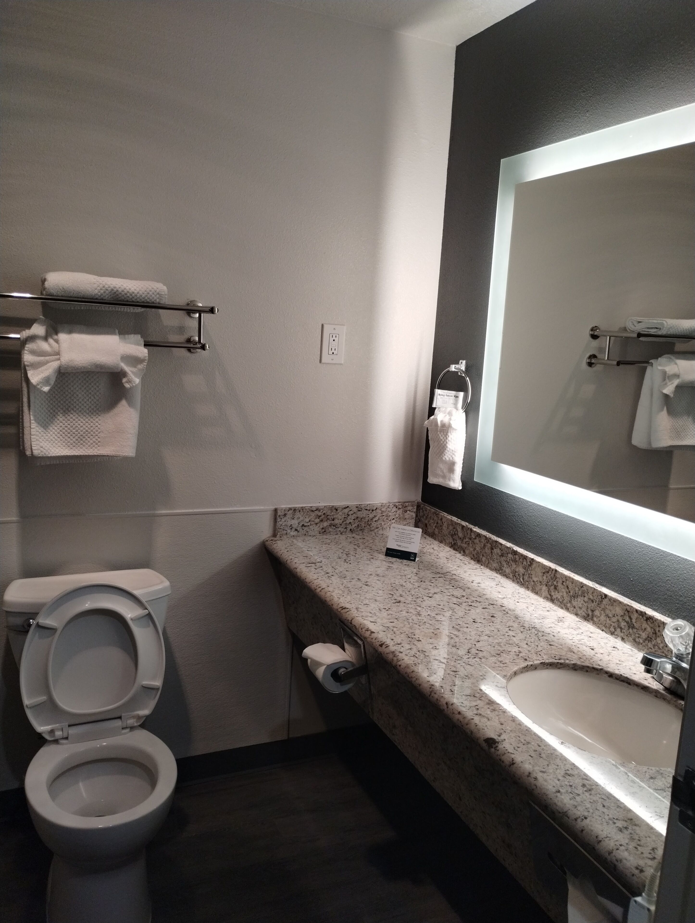 Un baño moderno con inodoro, lavabo y toalleros.