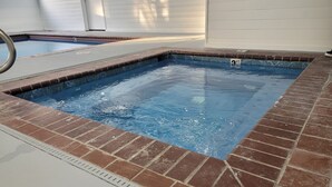 Piscina retangular com borda azulejada e revestimento de tijolos.