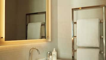 A modern bathroom with a large mirror, a sink, and a shower.