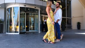 A couple standing in front of a building with a glass entrance and a sign that reads "DAN PANORAM HOTEL". - Dan Panorama Tel Aviv (Tel Aviv)
