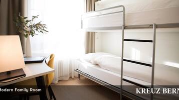 A modern family room with bunk beds, a desk, and a lamp.