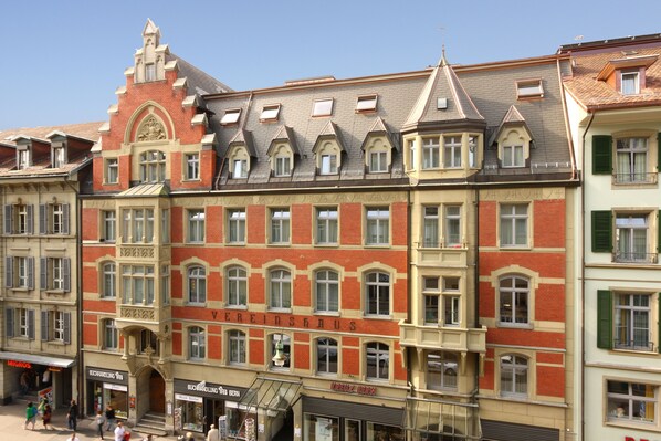 A historic building with multiple stories, large windows, and a prominent sign.