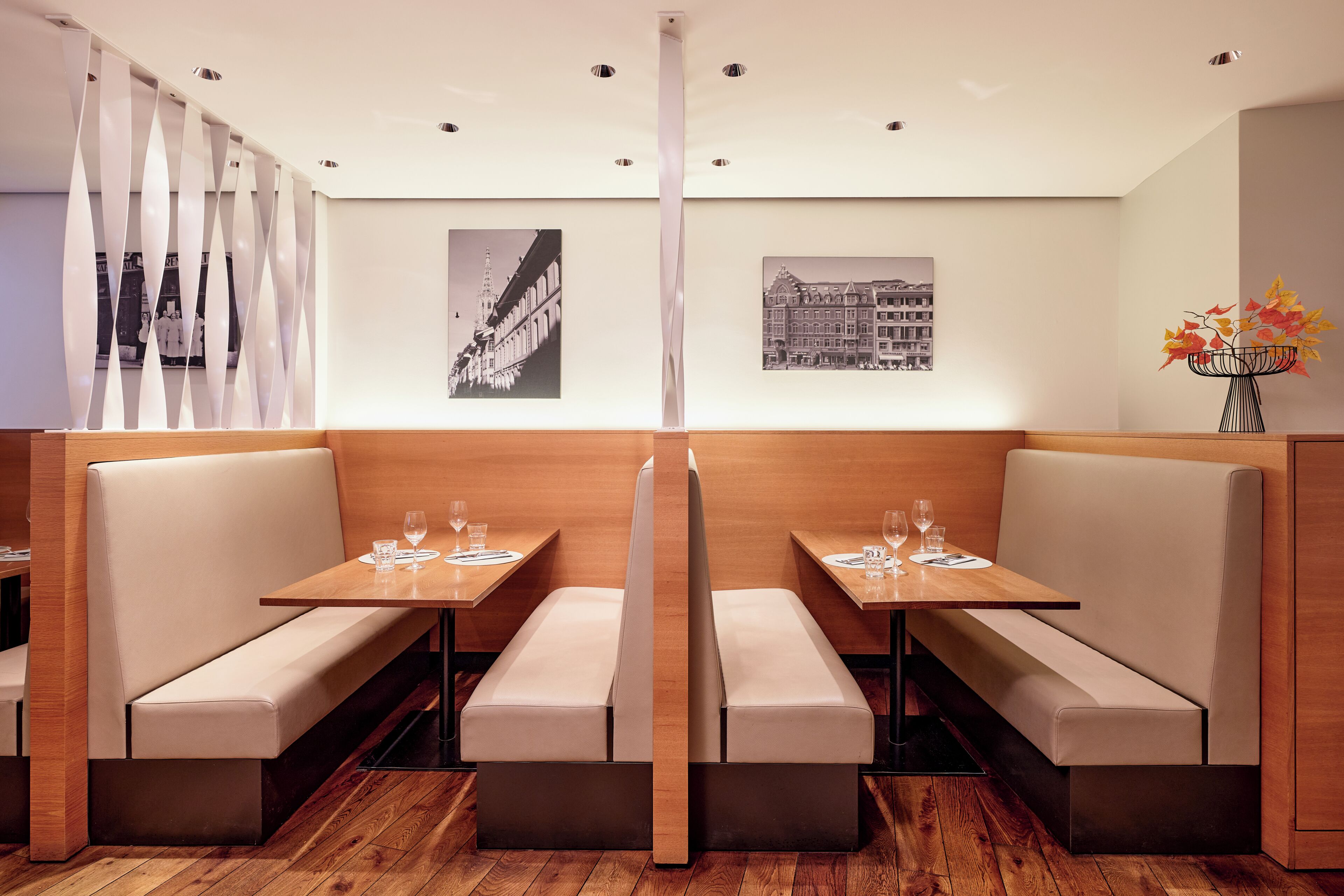 Un restaurante con asientos tipo cabina, mesas de madera y fotografías en blanco y negro en las paredes.