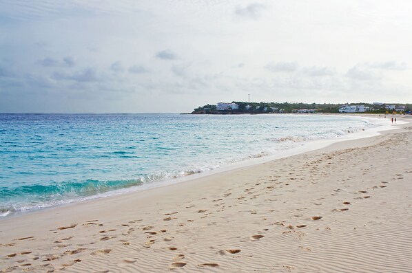 Una playa cerca, sillas reclinables de playa, sombrillas