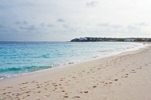 Una playa cerca, sillas reclinables de playa, sombrillas