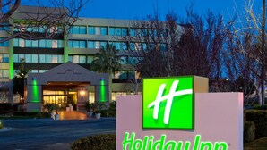 A Holiday Inn sign with a green logo and the name "Holiday Inn" in white letters. - Holiday Inn Palmdale-Lancaster by IHG (Palmdale)