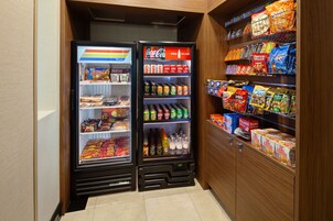 Máquina expendedora con refrigerios, bebidas y un refrigerador de Coca-Cola.