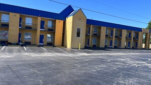A motel with multiple rooms, a parking lot, and a blue roof. - Super 8 by Wyndham Lumberton NC (Lumberton)