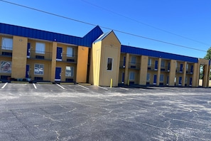 A motel with multiple rooms, a parking lot, and a blue roof. - Super 8 by Wyndham Lumberton NC (Lumberton)