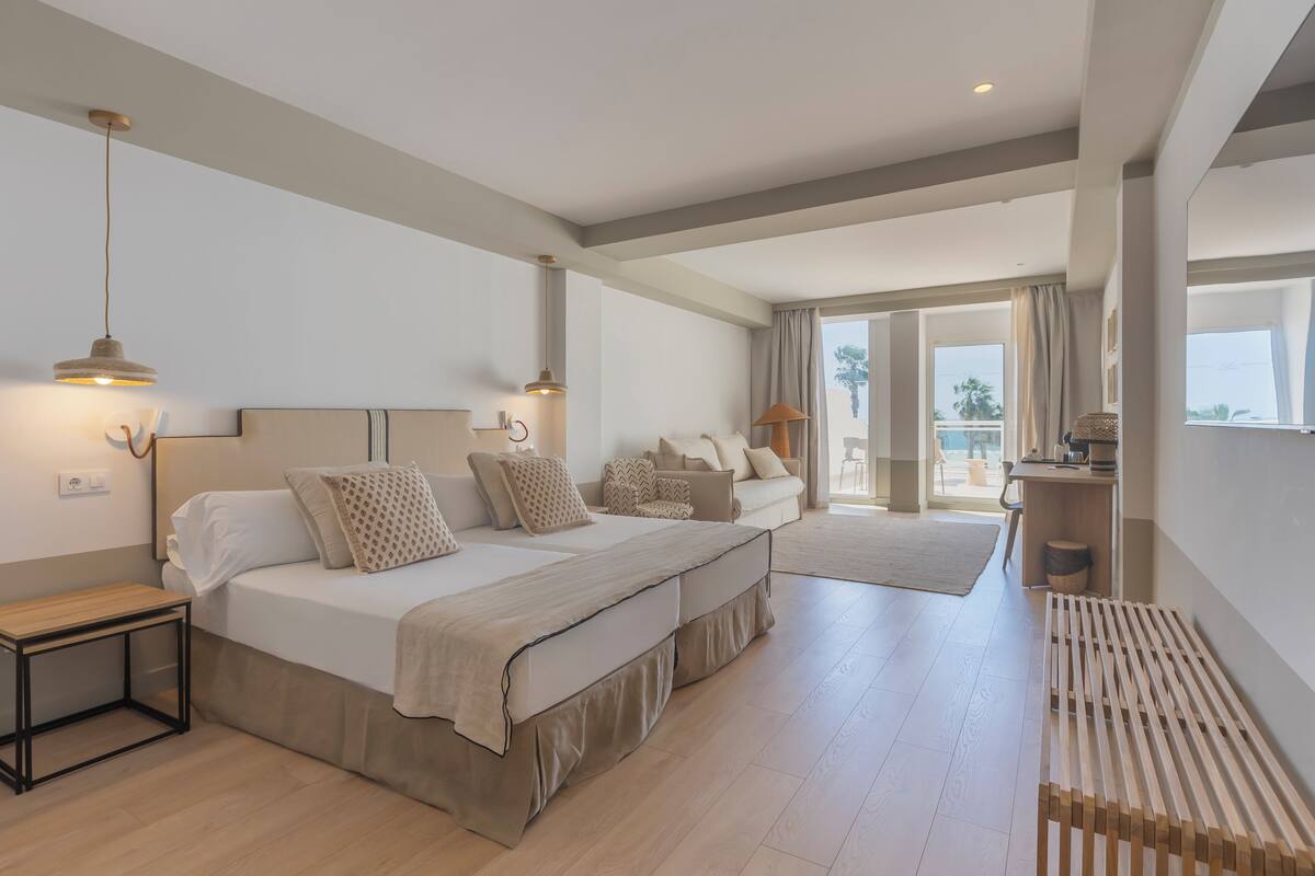 A spacious bedroom with a large bed, bedside tables, and a view of the outdoors.