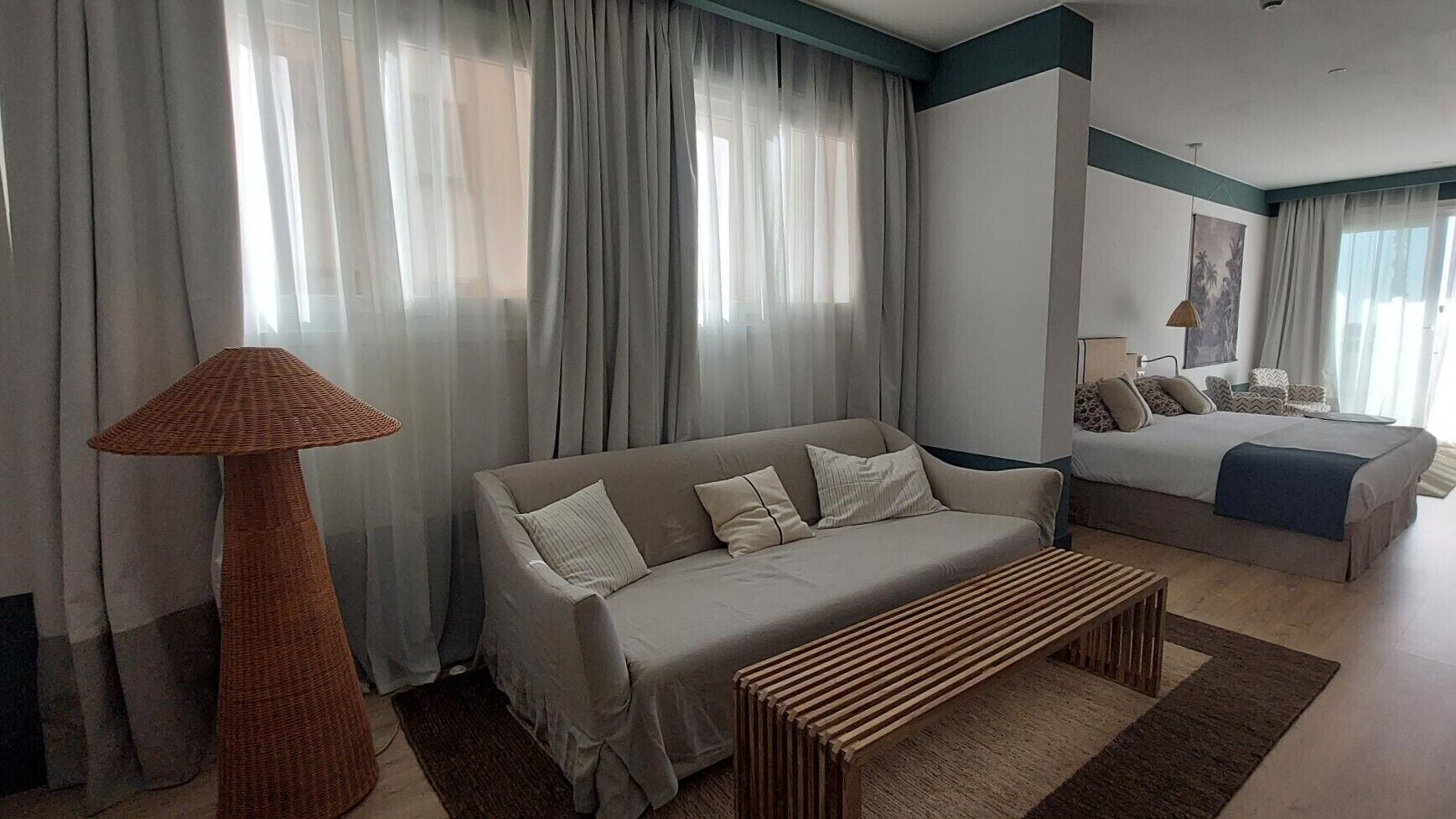A modern living room with a sofa, a bench, and a lamp.