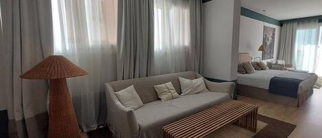 A modern living room with a sofa, a bench, and a lamp.