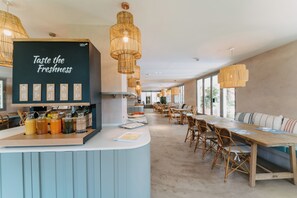 A modern dining area with a counter displaying beverages and a sign that reads "Taste the Freshness." - Petit Palace Las Vegas formerly known as Soho Boutique Las Vegas (Málaga)