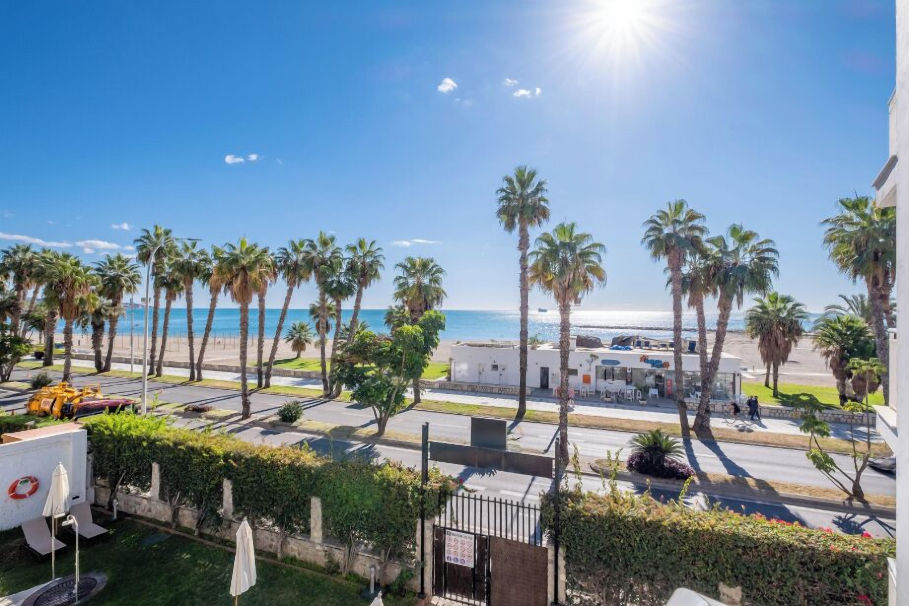 Ein Hotel an der Küste mit Palmen, Blick auf den Strand und einem Parkplatz.