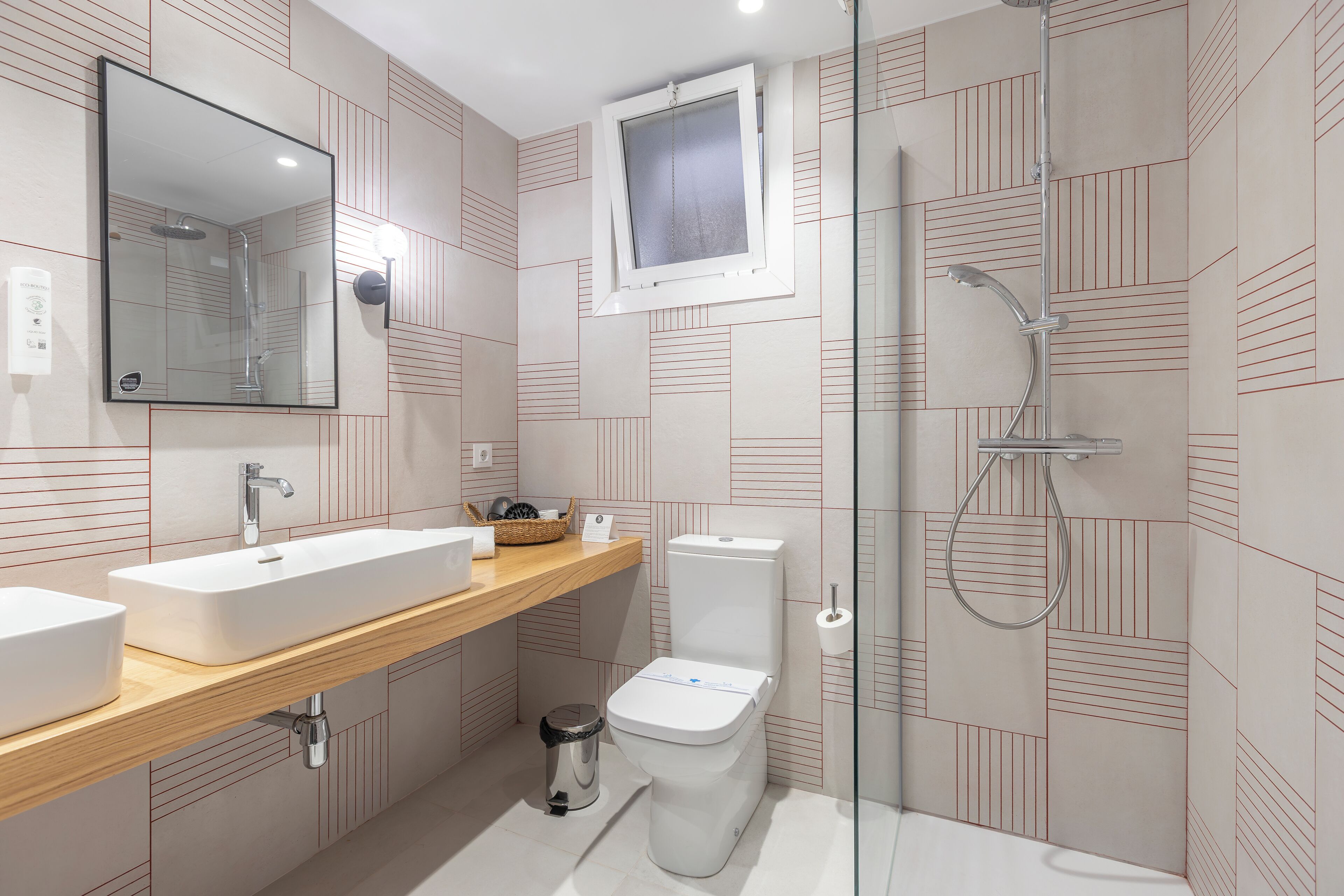 A modern bathroom with a rectangular sink, a toilet, and a glass-enclosed shower.
