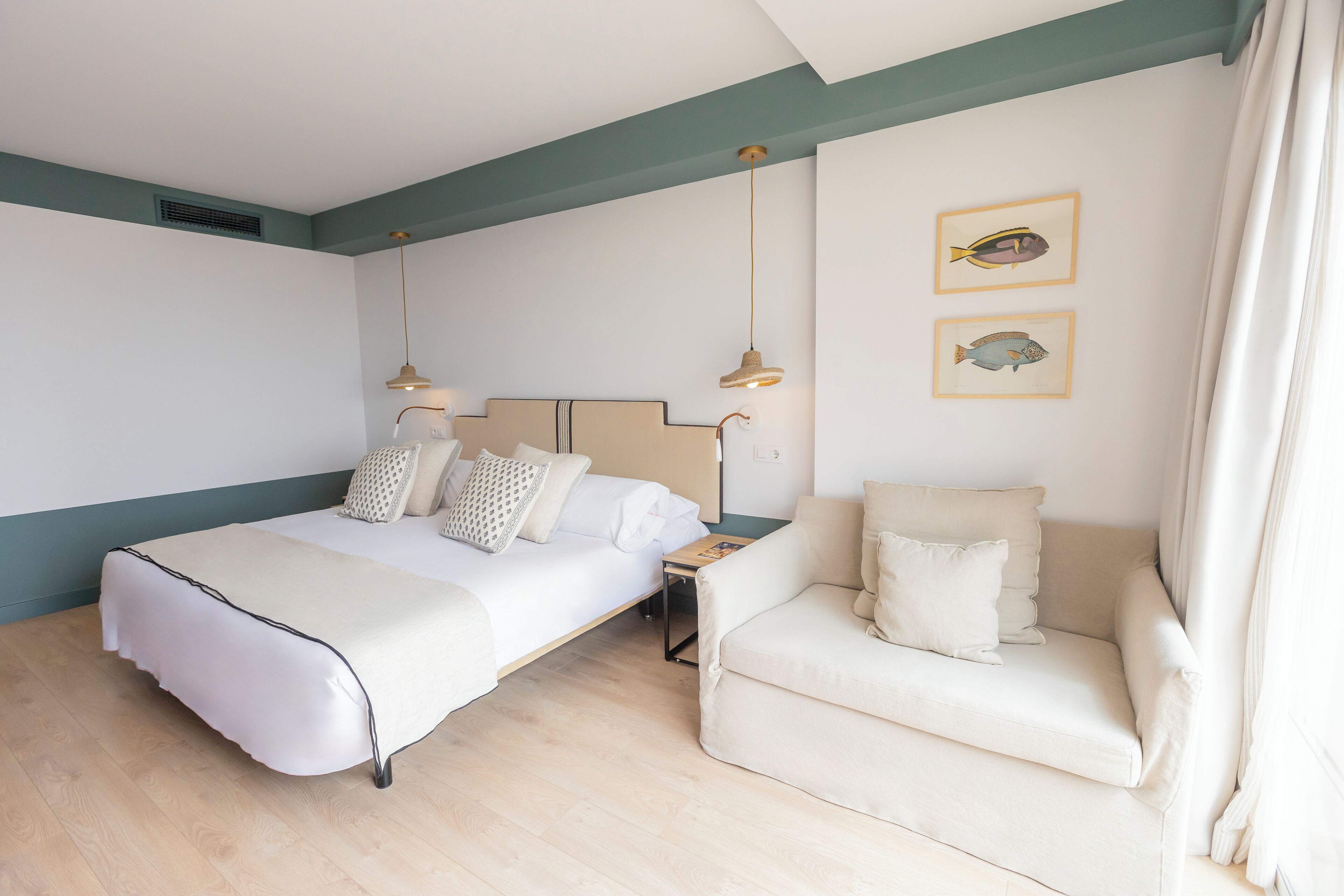 Een slaapkamer met een bed, nachtkastje en een bank.