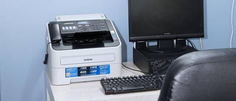 Un bureau avec une imprimante Brother, un écran Brother et un clavier.
