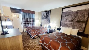 Una habitación de hotel con dos camas, un escritorio, un espejo y un ventanal con cortinas.