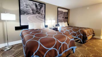 A hotel room with two beds, a large window, and a painting of a road and trees.