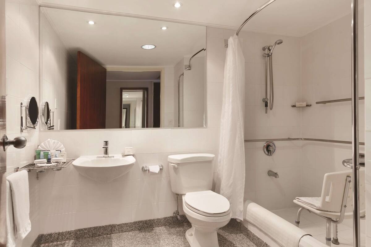 A modern bathroom with a sink, toilet, shower, and a glass-enclosed shower area.