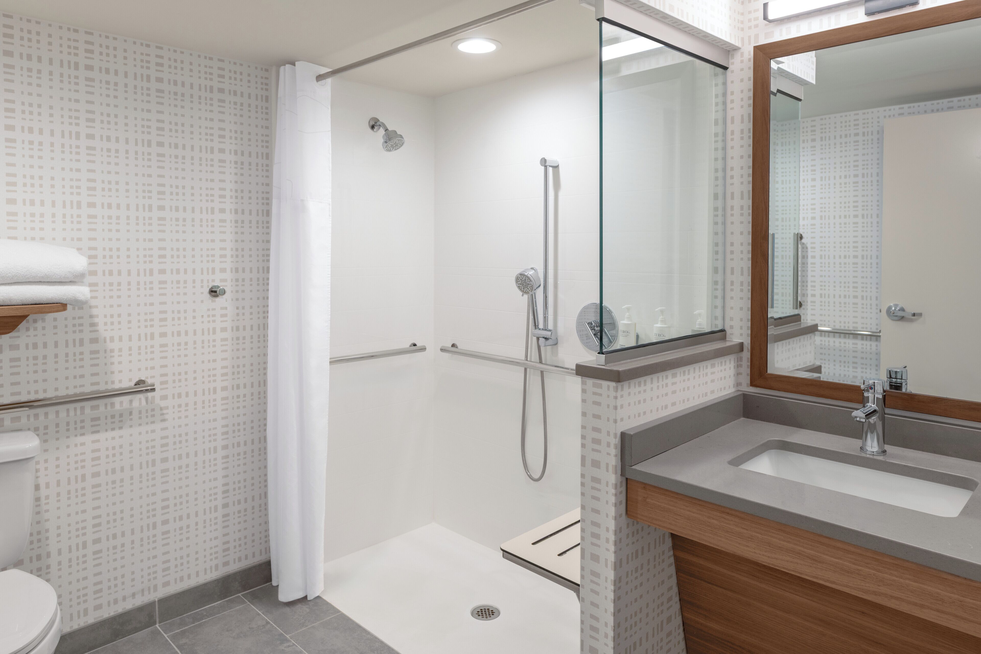 Un baño moderno con ducha, inodoro y lavabo.