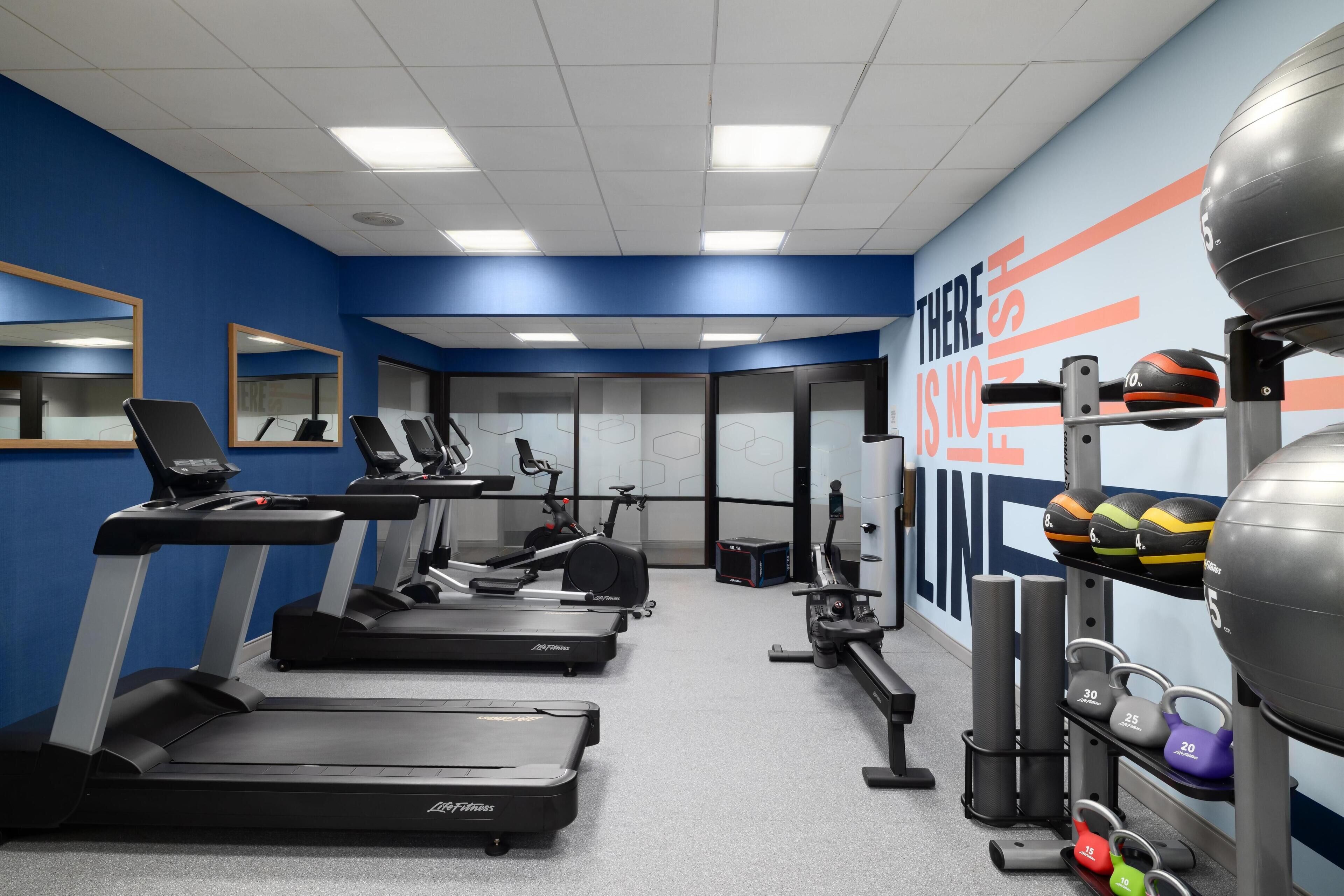 A gym with treadmills, exercise bikes, and weight equipment.