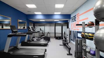 A gym with treadmills, exercise bikes, and weight equipment.