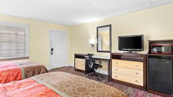 A hotel room with two beds, a desk with a chair, a television, a microwave, and a refrigerator.
