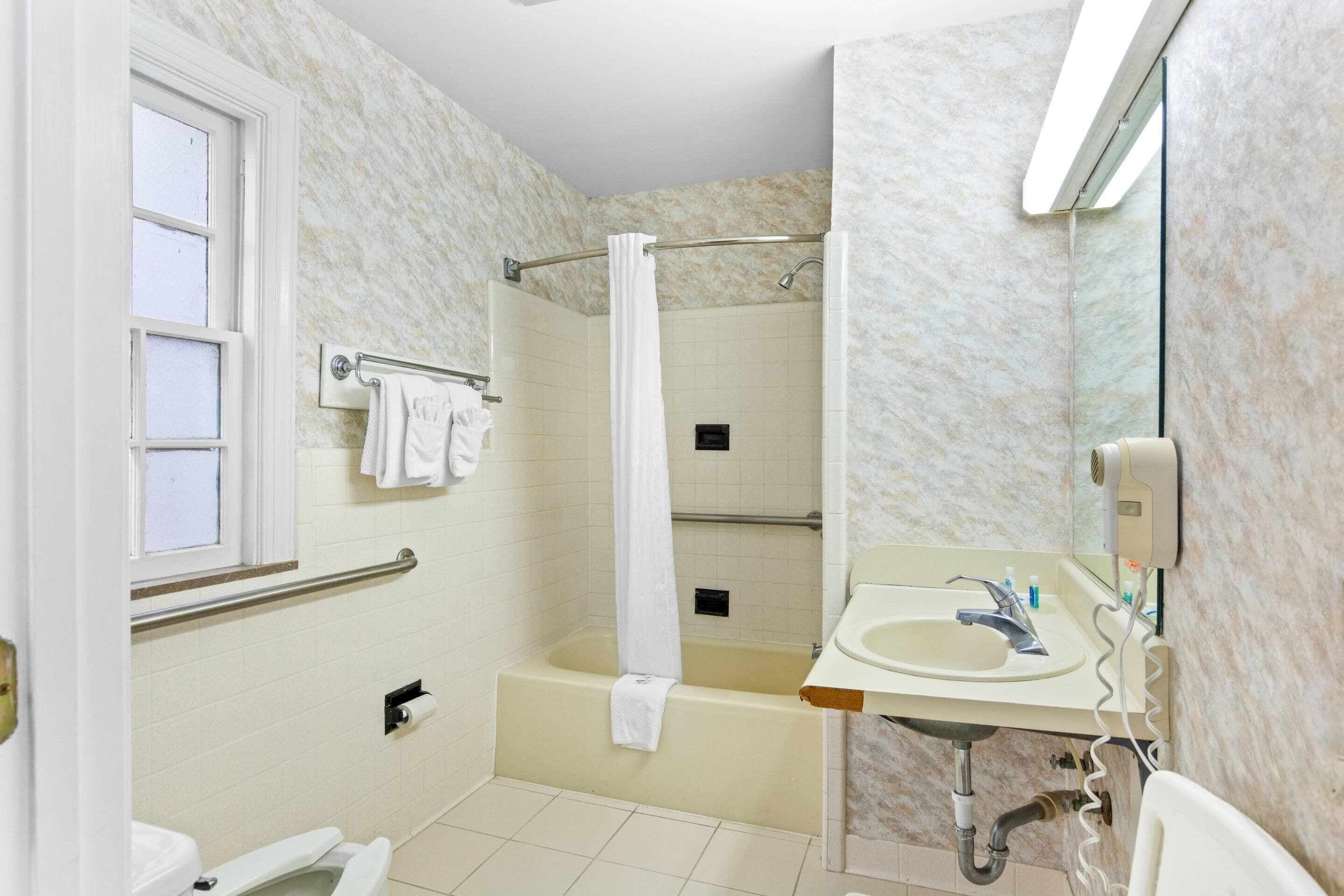 Un bagno con vasca, doccia, WC e lavandino.