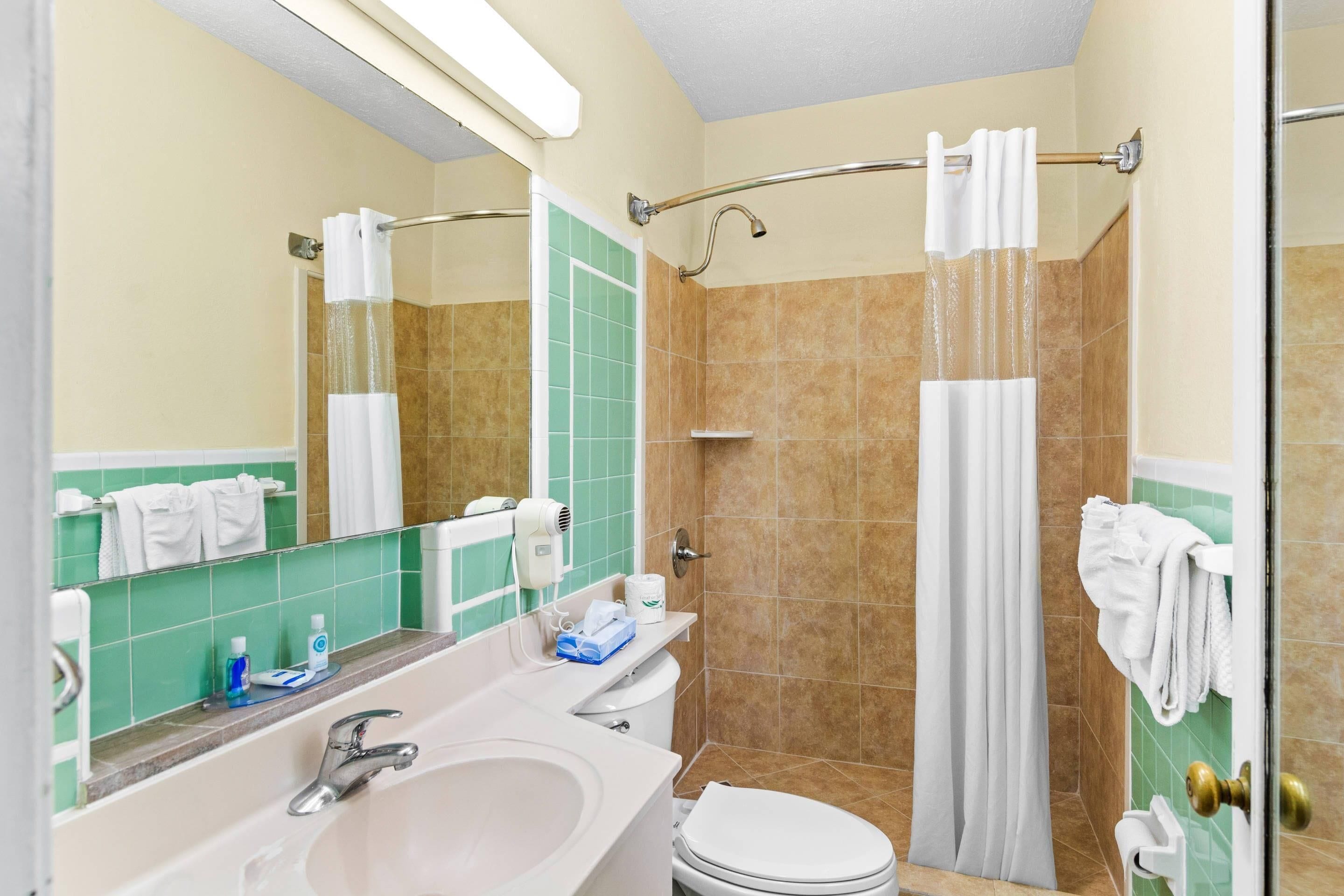 A bathroom with a sink, toilet, and shower.