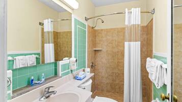 A bathroom with a sink, toilet, and shower.