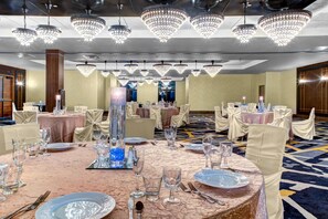 A banquet hall with round tables, chairs, and chandeliers. - DoubleTree by Hilton Hotel Arlington DFW South (Arlington)