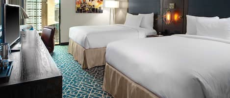 A hotel room with two beds, a desk, a chair, a lamp, and a cityscape view.