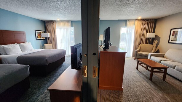 A hotel room with a bed, a desk, a chair, and a sofa. - Quality Inn and Suites Garden of the Gods (Colorado Springs)