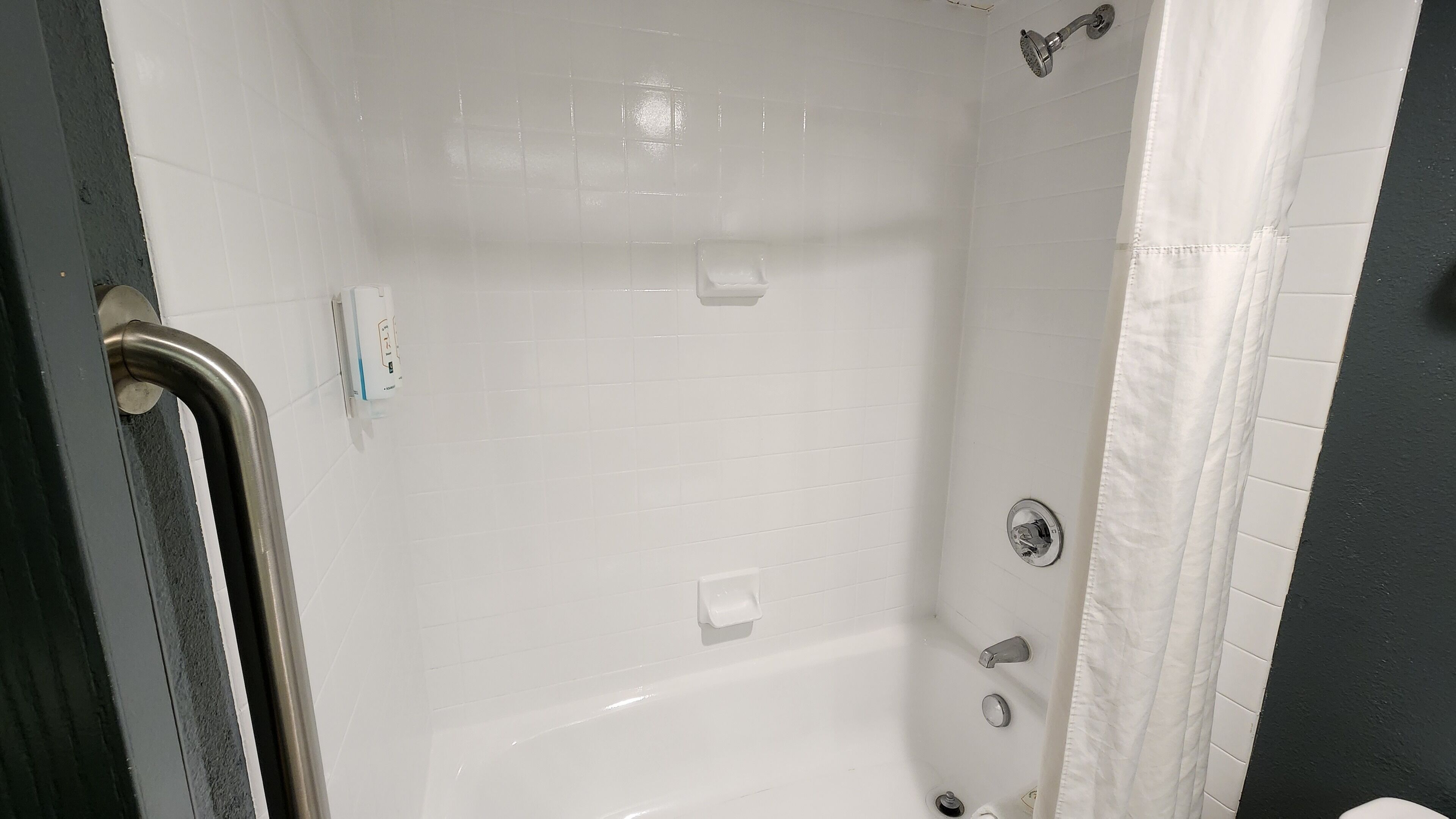 A bathroom with a white bathtub, a shower, and a toilet.